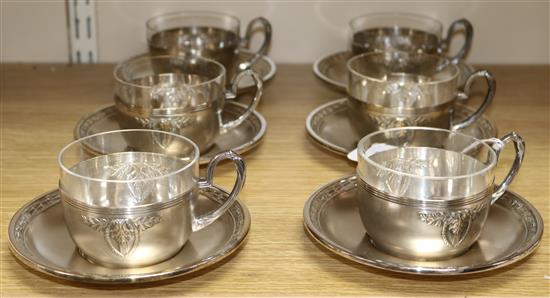 A set of six electroplate and glass tea cups and saucers